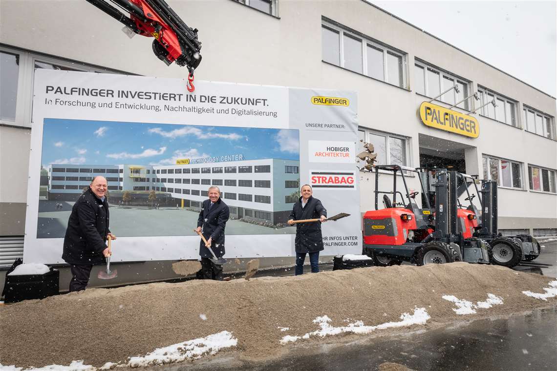 People standing in front of the billboard showing how the new centre will look