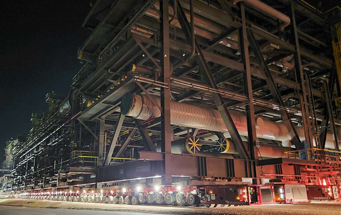 Large grey girder structure like a piperack lit up at night on 496 lines of red SPMT