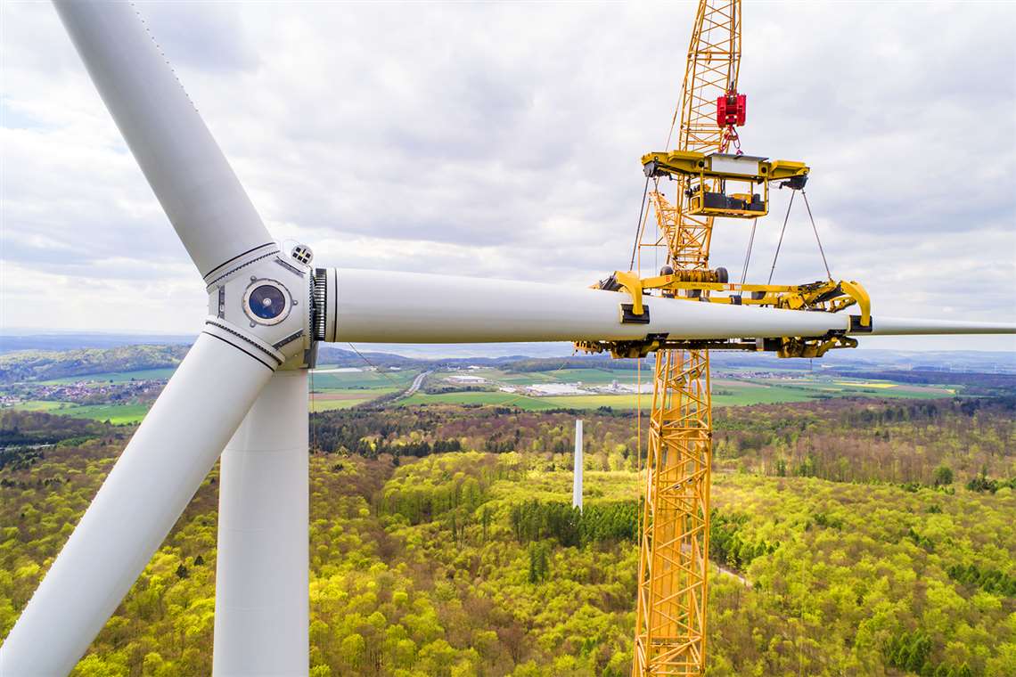 Installing a wind turbine blade using a big lattice crawler crane and specialized blade handling frames