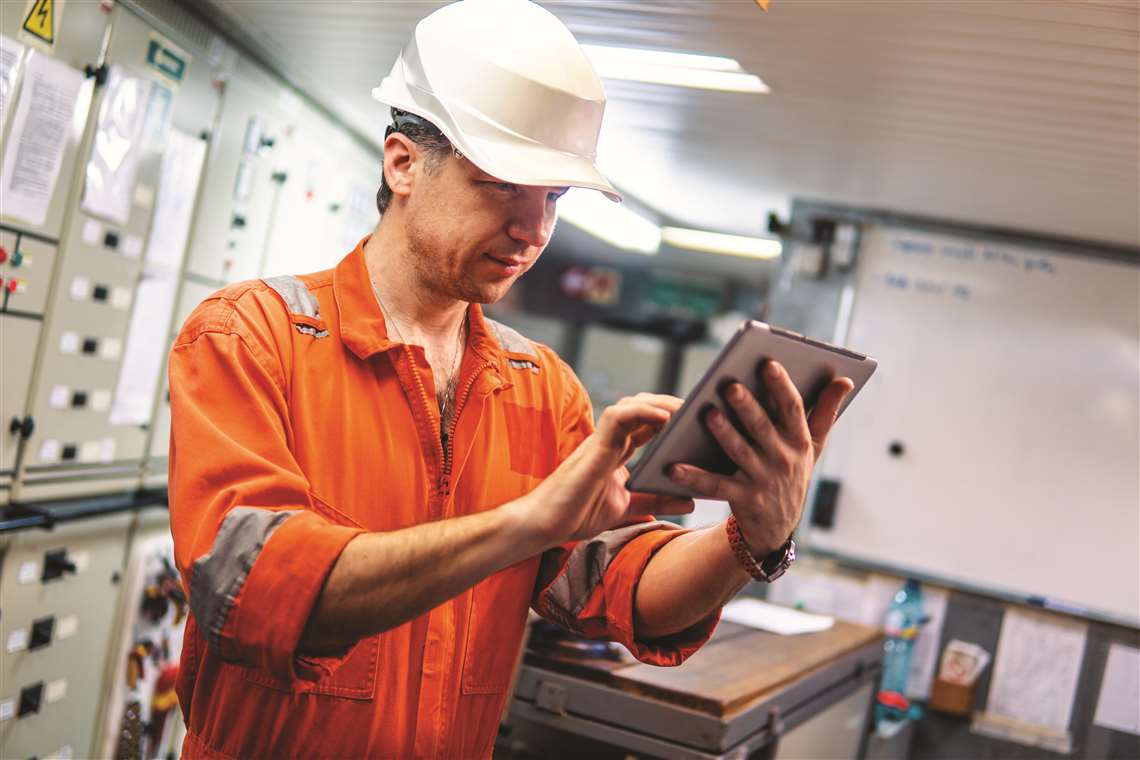 A marine engineer watching a digital tablet