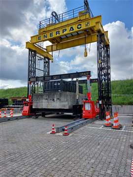 red Enerpac SL 200 hydraulic telescopic lifting gantry units set up with a black beam underneath a larger yellow and black Enerpac gantry tower system