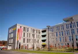 grey office building with Palfinger flags flying