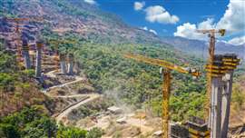 yellow flat top Potain tower cranes in a valley