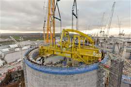 rotating yellow polar crane installed on its tracks in the top of the reactor building