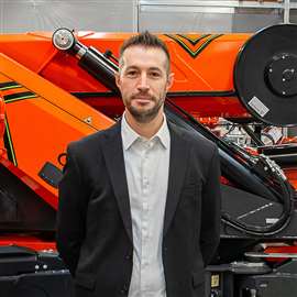 Mauro Tonon, Jekko operations director, standing in front of an orange Jekko mini crane. Photo: Jekko