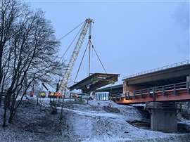 The floating crane hoists the eastern bridge section ashore. 