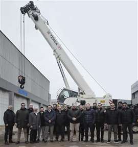 white Terex rough terrain crane behind a big lineup of Terex and TSM Global people