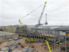 La grue sur socle à flèche en treillis Allelys d'une capacité de 1 000 tonnes est sur le point d'abaisser le séchoir dans le bâtiment