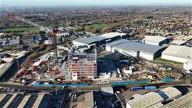 aerial view of jobsite with big red, white and black luffing jib Marr Contacting tower crane