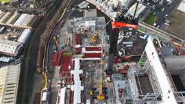 aerial view of jobsite with big red, white and black luffing jib Marr Contacting tower crane