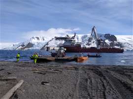 RT crane at a dock in Antarctica with snowy mountains behind