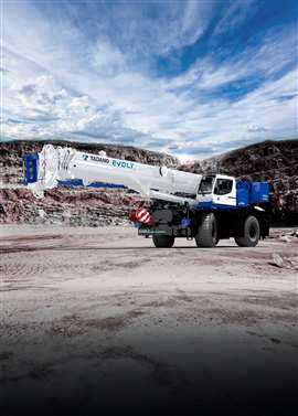 Blue and white Tadano electric RT crane in a quarry setting