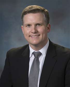 person in dark suit and tie: Chris Smith