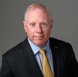 person in dark suit and tie: Mike Walsh