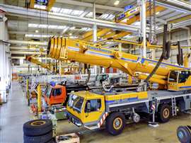 inside Liebherr's mobile crane repair shop in Germany with tele boom cranes lined up