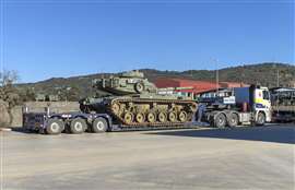 Army tank loaded on a commercial civilan operator's truck and trailer