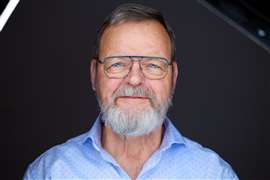 Bearded Ton Klijn, ESTA director, in open neck blue shirt, mugshot style photo