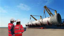 Deux personnes portant des gilets haute visibilité Fagioli et CEVA Logistics se tiennent devant un navire en train de décharger un grand bâtiment.