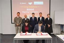 Gente de Sany Crane y del concesionario italiano Verdelli firmando un acuerdo con una fila de personas al fondo.