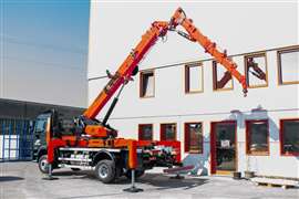 Jekko TRX80 naranja en posición de operación con estabilizadores desplegados y pluma hidráulica.