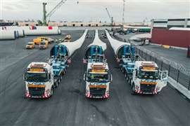 Three trucks with turbine blades ready to leave the port