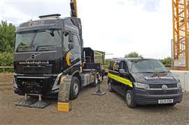 Black truck tractor and escort vehicle in Falcon livery