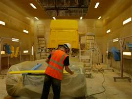 inside a large spray booth lit by those yellow sodium type lamps