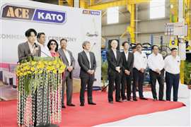 Fila de personas de Kato y ACE en un escenario de alfombra roja con telón de fondo de la empresa conjunta.