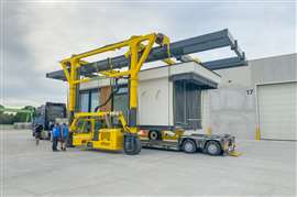 Modular housing unit is moved onto transport trailer