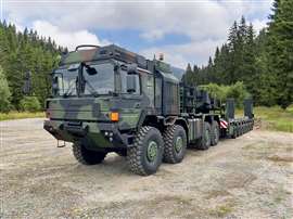 Camouflage painted Rheinmetall RMMV HX81 Elefant 2 heavy duty transporter pulling a multi-axle heavy duty trailer for combat vehicles