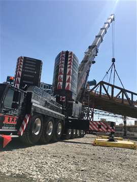 Grúa móvil de ruedas de gran tamaño de All Erection elevando un puente de celosía de acero con contrapeso completo.