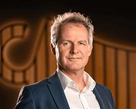 Jan Kleijn in abito scuro e camicia bianca