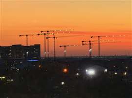 Soleil à Frisco, au Texas, avec les grues Uperio Zoomlion en silhouette.