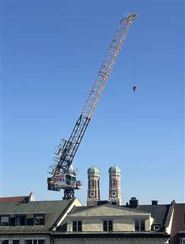 yellow and black Saez hydraulic luffing jib tower crane owned by BKL at work in Munich near the Frauenkirch