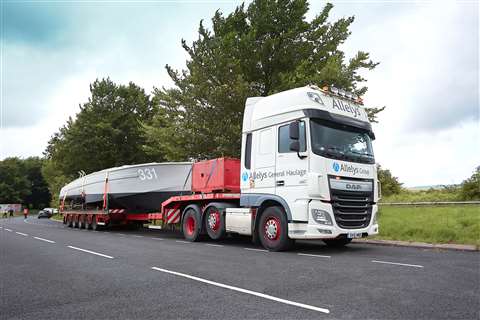 Old grey boat on a trailer behind a white truck