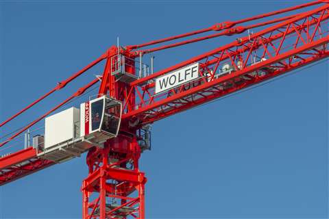 Red low top tower crane against bright blue sky