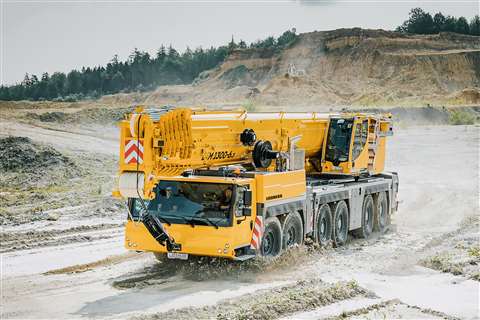 Yellow AT crane boom down in a mud hole