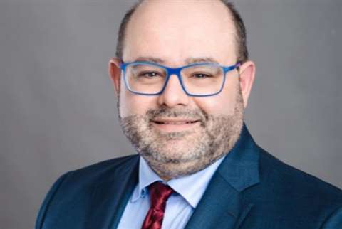 Man in suit, glasses, blue shirt, red tie