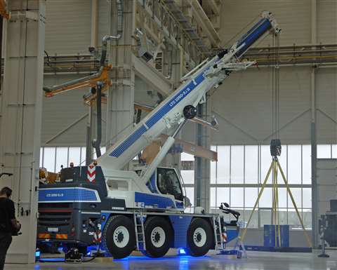 Blue and white crane lit up in factory at unveiling ceremony