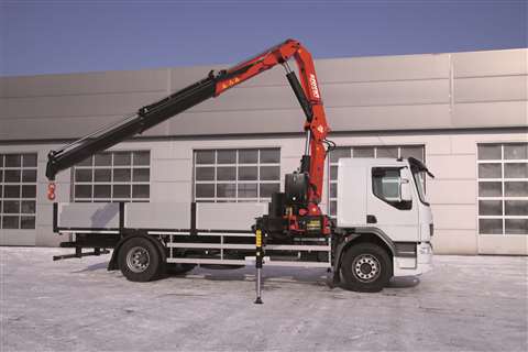 Red and black crane extended behind cab of small 2 axle truck