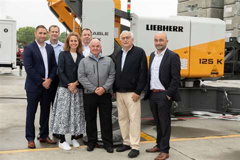 People lined up in front of a crane