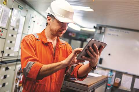 A marine engineer watching a digital tablet