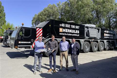 four people with a big key in front of a black crane