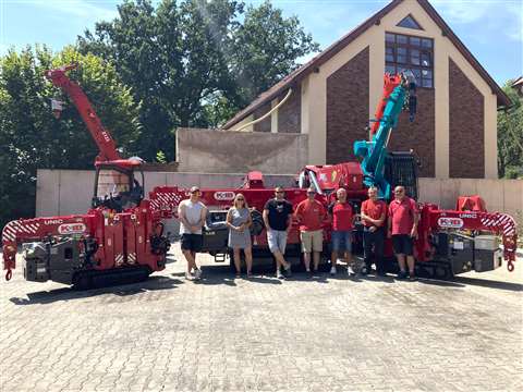 people standing in front of red cranes