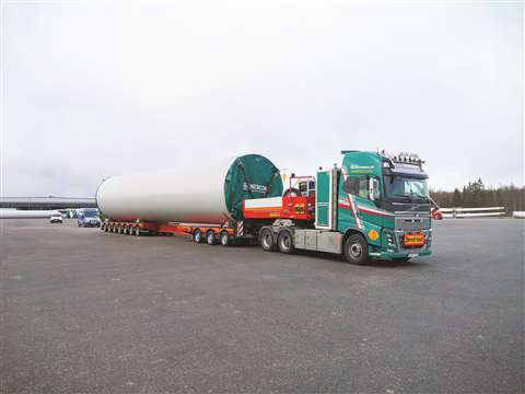 A vehicle transports turbine towers