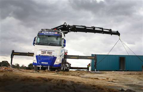 black crane extended from the side of a white truck