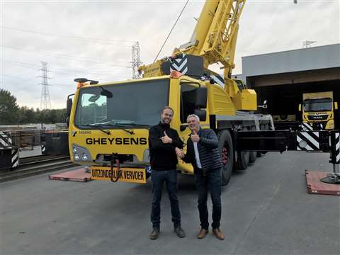 yellow crane, stowed for the road, with two people