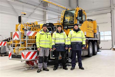 Schmidbauer people in high-vis standing in front of a yellow Tadano AC 3.045-1 City crane
