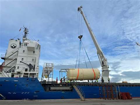 One of the industrial tanks is lowered onto a cargo vessel.