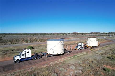 Two heavy haulage trucks transporting a tank each across land